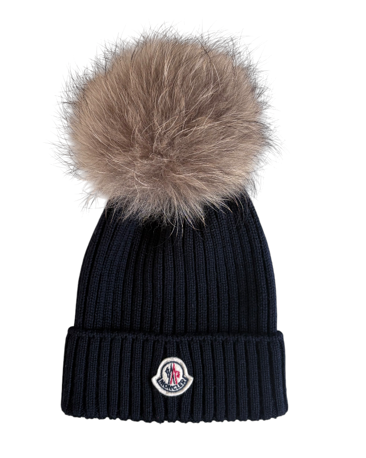 Navy blue beanie with fur pom-pom and Moncler logo on a white background